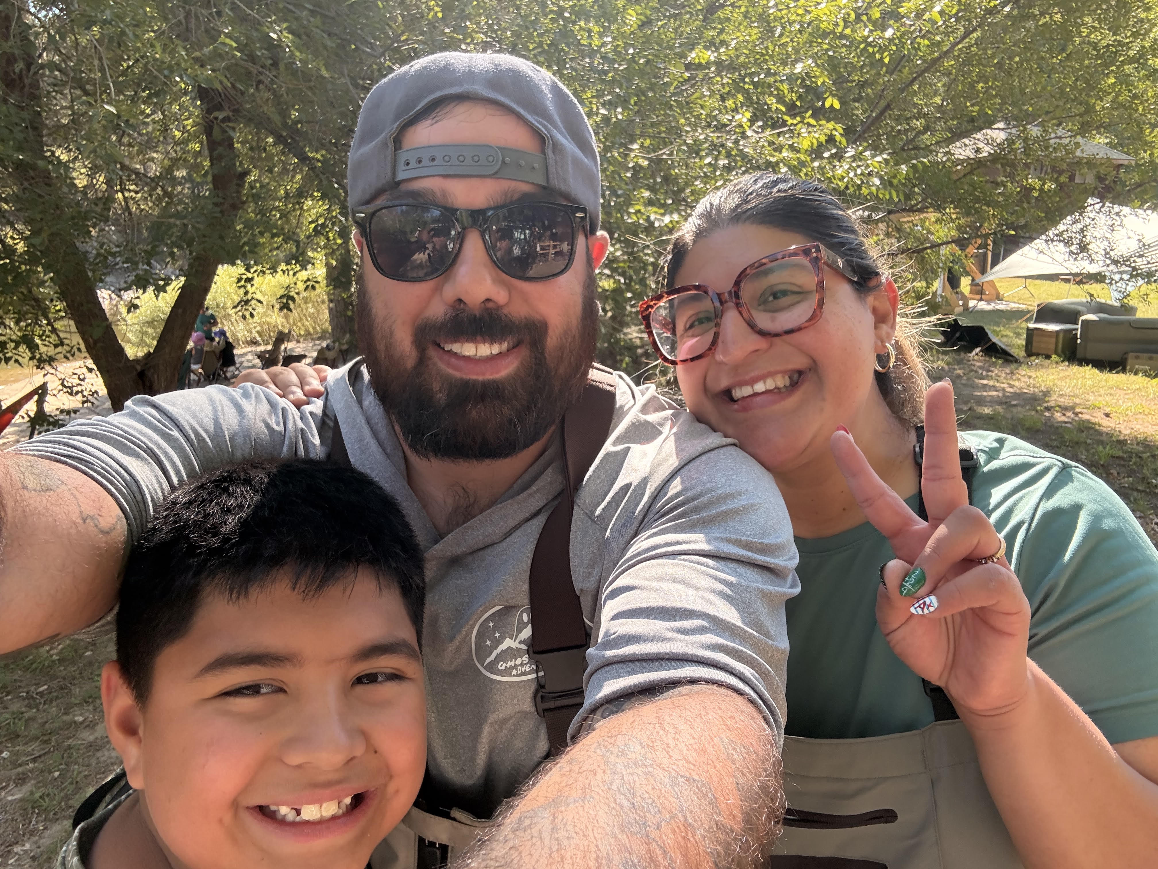 Roman, Michelle, and Jonah together outdoors at camp
